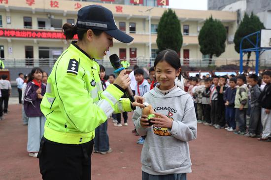撒拉溪镇中心校受聘仪式现场 交警赠送玩偶“交警小熊” 。邱梦如 摄