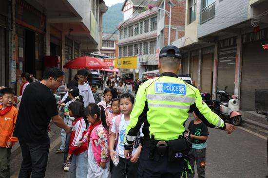 在长春堡镇中心校门口 交警带领新受聘的“小小宣传员”开展实地执法体验 对不文明行为进行劝导。 邱梦如 摄