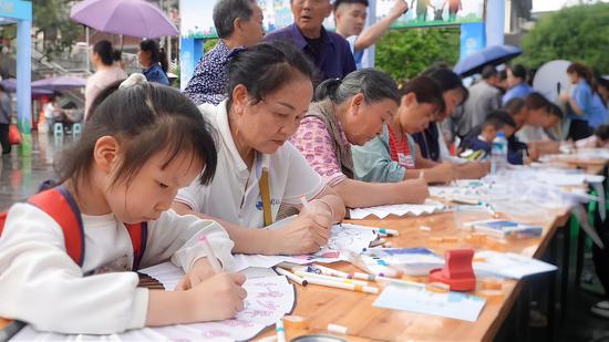 游园会的“绘净·无毒工坊”区域，市民们积极参与中。