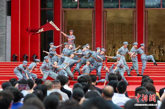 6月28日，新长征路上——纪念红军长征胜利90周年电影主题活动在位于贵州省遵义市的遵义会议陈列馆广场举行。活动由电影频道、遵义市委宣传部主办，以长征题材精品电影为依托，邀请了知名电影人、音乐人等文艺工作者以多元文艺形式讲述中国工农红军长征故事。图为开场情景表演《从这里出发》。 中新社记者 瞿宏伦 摄
