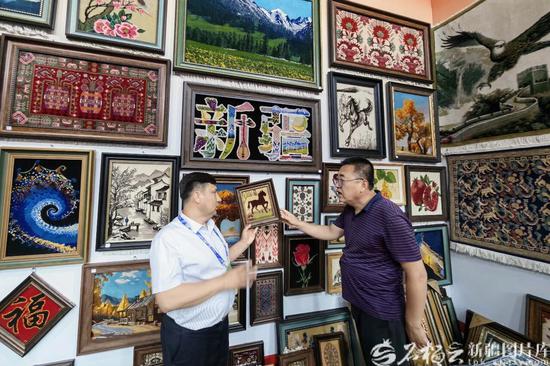6月25日，参展商在非物质文化遗产展位上参观。e
