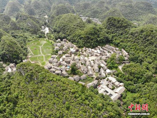 贵州省安顺市镇宁布依族苗族自治县高荡村,有近千年历史,是贵州省现存少有的布依族古村落。高荡村,布依族语称 “翁座”,从高处俯瞰,高荡村恰似群峰托起的一口巨锅。这里青石垒就的屋舍错落有致,蜿蜒的石巷曲径通幽,沧桑的古屯堡建筑默然矗立。近年来,高荡村陆续获得“国家森林乡村”“全国乡村旅游重点村”“全国生态文化村”等称号。图为7月4日,航拍贵州省安顺市镇宁布依族苗族自治县高荡村。石小杰 摄 贵州省安顺市镇宁布依族苗族自治县高荡村,有近千年历史,是贵州省现存少有的布依族古村落。高荡村,布依族语称 “翁座”,从高处俯瞰,高荡村恰似群峰托起的一口巨锅。这里青石垒就的屋舍错落有致,蜿蜒的石巷曲径通幽,沧桑的古屯堡建筑默然矗立。近年来,高荡村陆续获得“国家森林乡村”“全国乡村旅游重点村”“全国生态文化村”等称号。图为7月4日,航拍贵州省安顺市镇宁布依族苗族自治县高荡村。石小杰 摄
