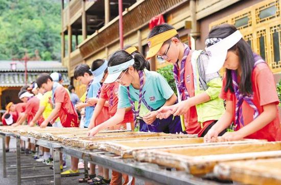游客在石桥村古法造纸工坊体验花草纸制作。 通讯员 陈焕春 摄 游客在石桥村古法造纸工坊体验花草纸制作。 通讯员 陈焕春 摄