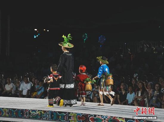 7月4日晚,贵州省凯里市苗侗风情园内,市民和游客在观看“村T”走秀。记者 周燕玲 摄 7月4日晚,贵州省凯里市苗侗风情园内,市民和游客在观看“村T”走秀。记者 周燕玲 摄