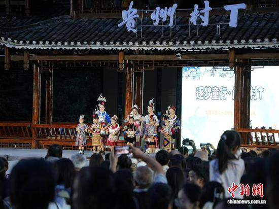 7月4日晚,贵州省凯里市苗侗风情园内,当地学生和老师身着民族服饰,共同走上“村T”舞台,吸引众多市民游客驻足观赏。记者 周燕玲 摄 7月4日晚,贵州省凯里市苗侗风情园内,当地学生和老师身着民族服饰,共同走上“村T”舞台,吸引众多市民游客驻足观赏。记者 周燕玲 摄