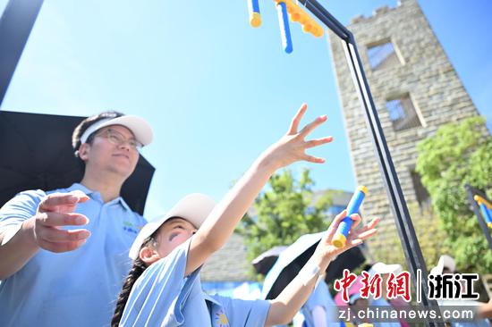 图为：孩子和家长在“国寿700健行”活动中体验闯关打卡游戏。中新社记者 王刚 摄