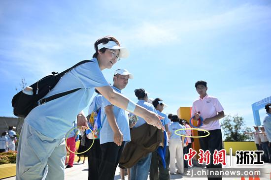图为：家长在“国寿700健行”中体验闯关打卡游戏。中新社记者 王刚 摄