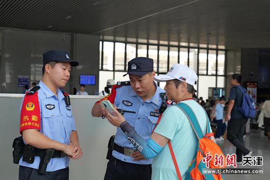 图为北京铁路公安局天津公安处秦皇岛站派出所民警正在解决旅客的问询。(北京铁路公安局天津公安处供图) 图为北京铁路公安局天津公安处秦皇岛站派出所民警正在解决旅客的问询。(北京铁路公安局天津公安处供图)