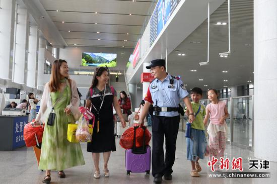 图为北京铁路公安局天津公安处北戴河站派出所民警帮助旅客拿行李,确保旅客和儿童能够顺利乘车。(北京铁路公安局天津公安处供图) 图为北京铁路公安局天津公安处北戴河站派出所民警帮助旅客拿行李,确保旅客和儿童能够顺利乘车。(北京铁路公安局天津公安处供图)