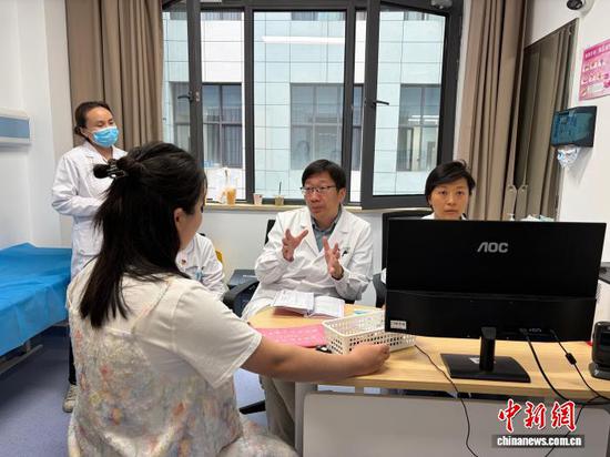 图为北京协和医院风湿免疫科副主任赵久良(中)在贵州省人民医院给患者看诊。中新网记者 周燕玲 摄