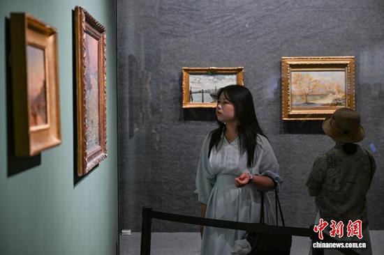 图为参观者在观看加斯顿·普尼耶的作品《日落印象》。中新社记者 瞿宏伦 摄