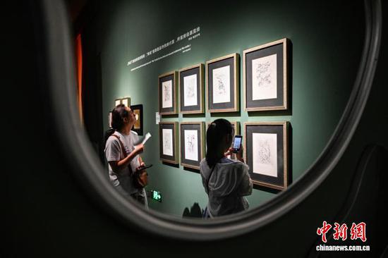 图为参观者在观看萨尔瓦多·达利签名版画系列作品。中新社记者 瞿宏伦 摄