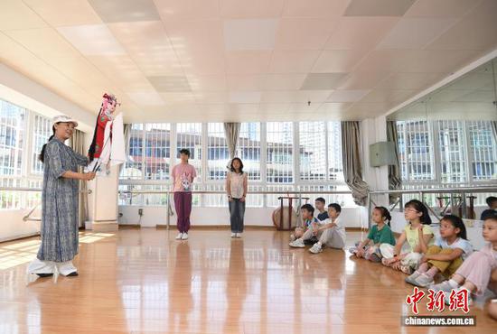 图为木偶老师正在给小朋友们讲解木偶表演基础动作要领。赵松 摄