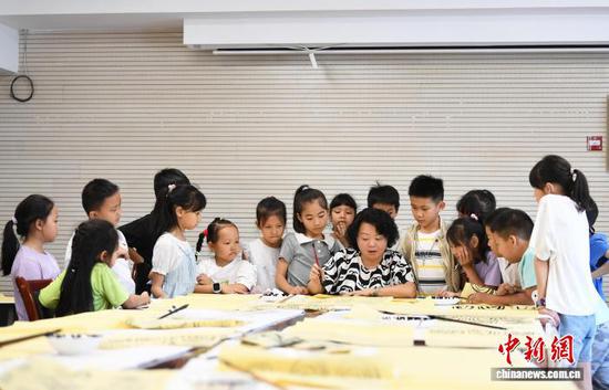 图为书法老师正在指导小朋友们进行书法基本功练习。赵松 摄