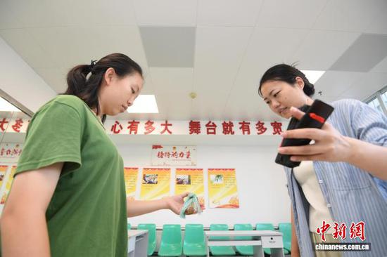 图为一名小朋友正在老师的指导下学习打快板。赵松 摄