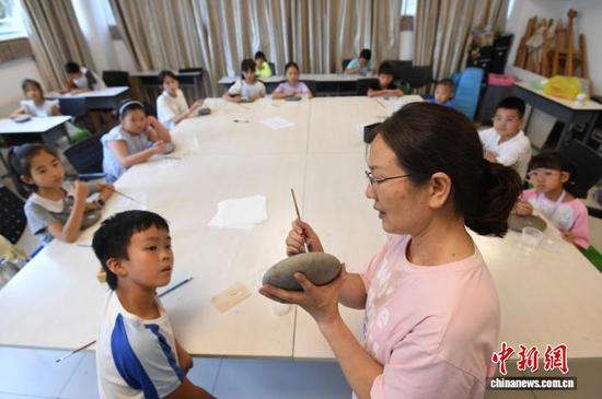7月13日，贵阳市南明区文化馆2026年暑期公益艺术培训班开课，该馆通过开设书法、美术手工、越剧等多项免费公益课程，丰富青少年暑期生活。图为美术手工老师正在指导小朋友们进行石绘。赵松 摄