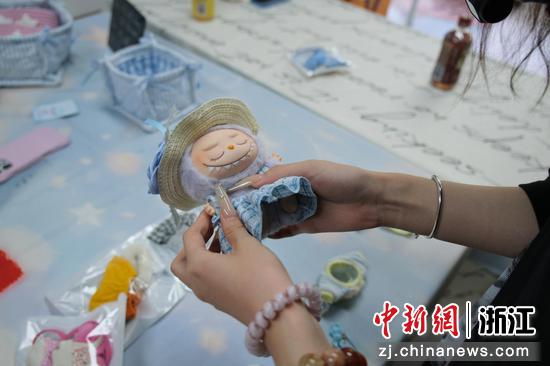 7月3日,陈玟希正在给拉布布穿娃衣。曹丹 摄 7月3日,陈玟希正在给拉布布穿娃衣。曹丹 摄