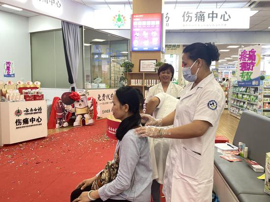 图为南宁市老百姓大药房津头店,云南白药伤痛中心的工作人员在为市民免费康复指导服务。武慧 摄 图为南宁市老百姓大药房津头店,云南白药伤痛中心的工作人员在为市民免费康复指导服务。武慧 摄