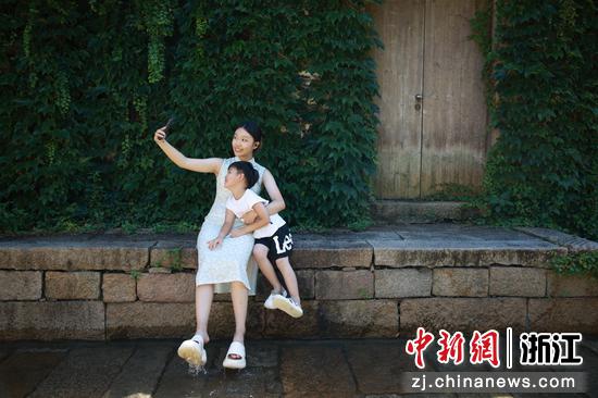 图为7月15日,游客在“凉街踩水”活动中,拍照打卡。孙杨洋 摄 图为7月15日,游客在“凉街踩水”活动中,拍照打卡。孙杨洋 摄