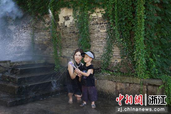 图为7月15日,小朋友和妈妈在玩水嬉戏。孙杨洋 摄 图为7月15日,小朋友和妈妈在玩水嬉戏。孙杨洋 摄