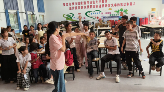 实践团成员在课堂上带领孩子“红领巾小巴扎”积分盲盒体验。