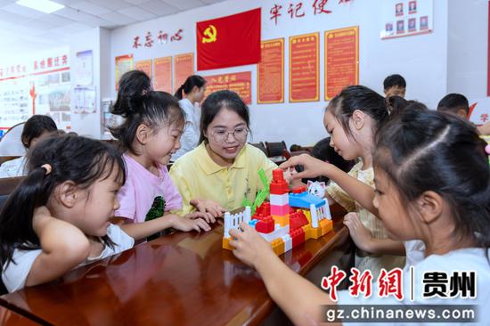 2026年7月16日,在贵州省黔南布依族苗族自治州罗甸县斛兴街道学府社区,大学生志愿者与小朋友一起堆积木。 2026年7月16日,在贵州省黔南布依族苗族自治州罗甸县斛兴街道学府社区,大学生志愿者与小朋友一起堆积木。