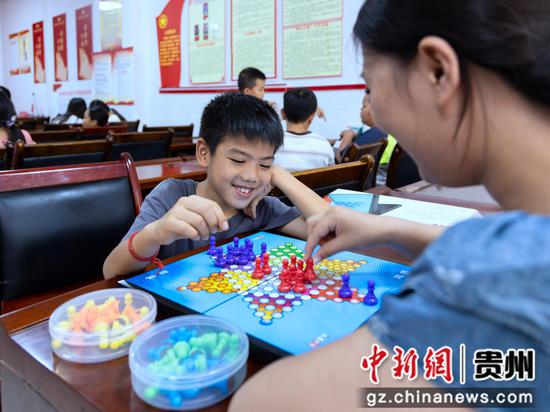 2026年7月16日,在贵州省黔南布依族苗族自治州罗甸县斛兴街道学府社区,大学生志愿者教小朋友下跳棋。 2026年7月16日,在贵州省黔南布依族苗族自治州罗甸县斛兴街道学府社区,大学生志愿者教小朋友下跳棋。