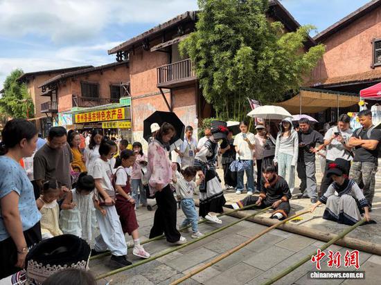 图为游客在贵州六盘水市水城区海坪彝族文化小镇体验民俗活动。记者 周燕玲 摄