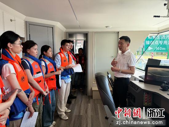 史旭初向实践团成员介绍水上服务区功能布局、岸电设施配置及湖州船舶电动化发展趋势。湖州师范大学供图