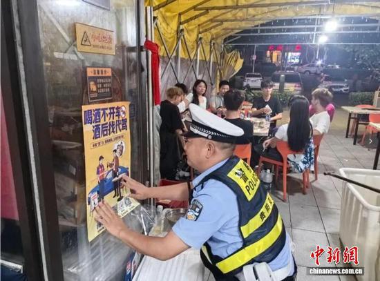图为贵州交警在夜市开展“拒绝酒驾”交通安全宣传活动。　贵州交警供图
