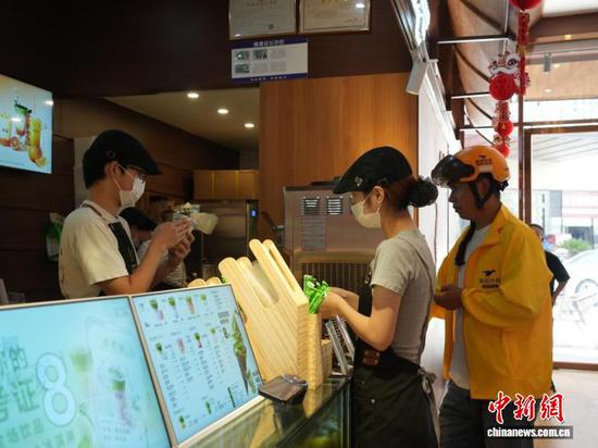 图为贵州省德江县一家新茶饮门店的工作人员在制作抹茶饮品。王显 摄