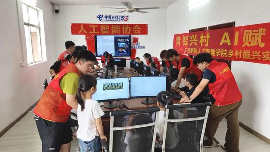 图为大学生在给村里孩子上AI启蒙课。覃裕镔 摄