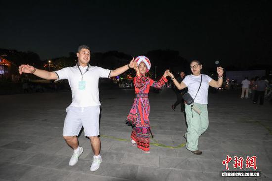 7月21日，采访团成员在晴隆县学习跳“阿妹戚托”舞蹈。 中新社记者 瞿宏伦 摄
