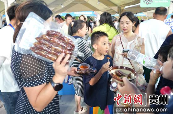 图为试吃区内各类独具贵州风味的特色农产品让游客赞不绝口。