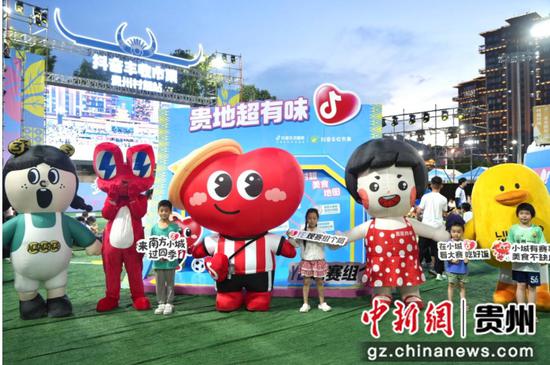 图为游客选购好农产品后在打卡点留影。