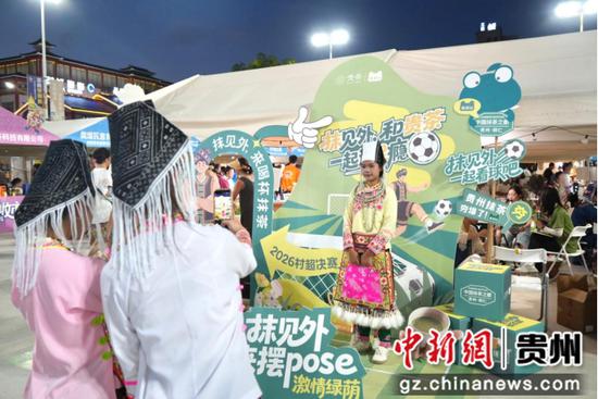 图为游客在参展商家打卡点拍照留念。