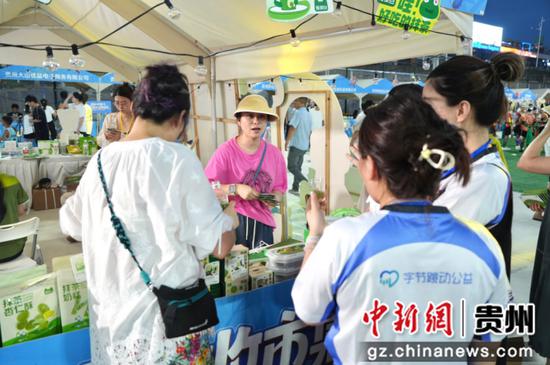 图为商家工作人员也热情地向每一位路过的游客介绍参展的特色产品与专属优惠。