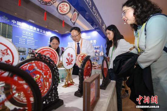 图为嘉宾在非遗展区制作漆扇。中新社记者 瞿宏伦 摄 图为嘉宾在非遗展区制作漆扇。中新社记者 瞿宏伦 摄