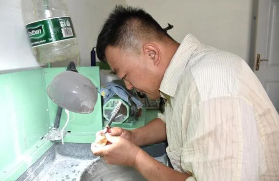 穆佳在工作室雕刻作品。买合木提 摄