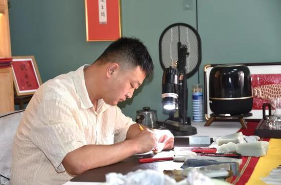 穆佳在工作室雕刻作品。买合木提 摄c