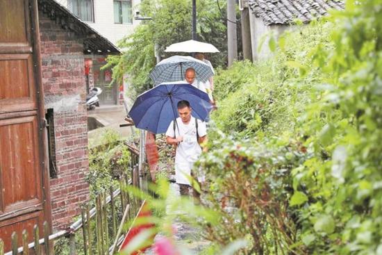龙昭国（前一）和同事赶往村民家中。 通讯员 杨晓海 摄