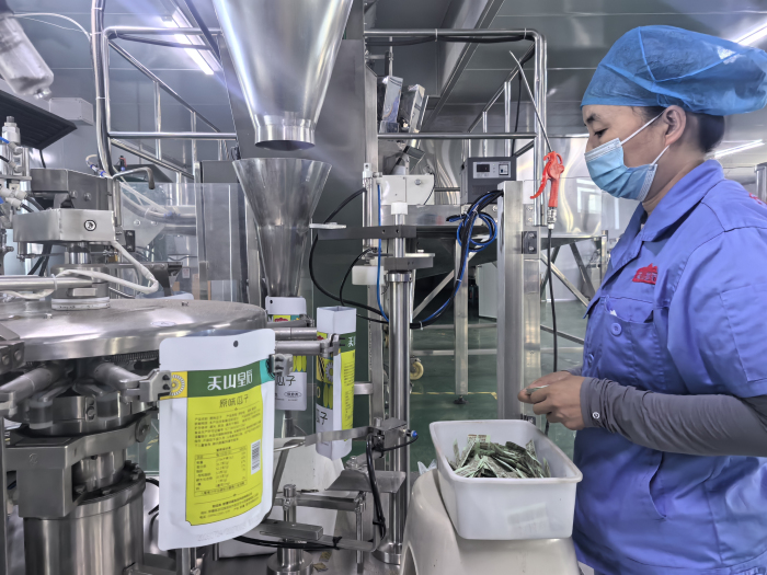 图为新疆华峰食品科技有限公司生产车间工人正在包装休闲食品瓜子。马月 摄