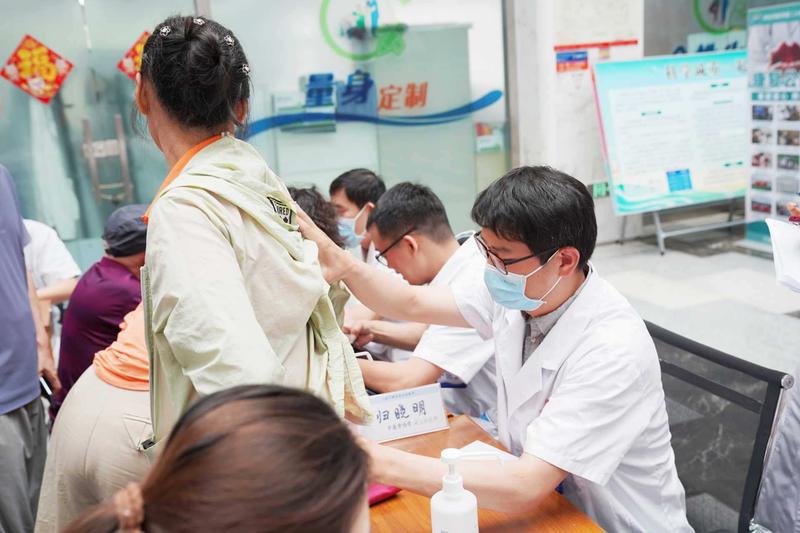 上海专家细致询问患者身体状况、耐心倾听病情描述，逐一仔细核对检查资料。邓雨欣 摄