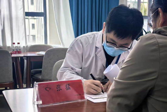 北京燕化医院骨科副主任医师张猛正在为患者诊断病情。