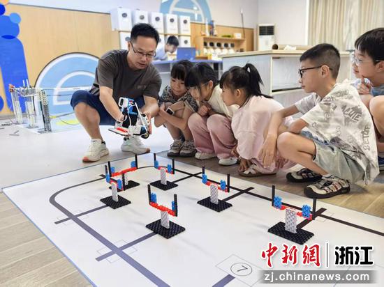 直埠小学副校长郭高广带领学生了解机器人编程。（资料图，诸暨市教育技术中心供图）