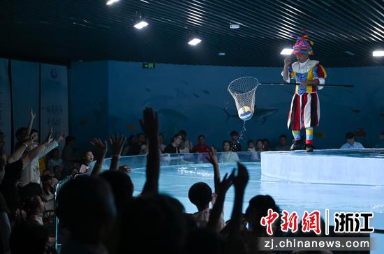 图为：水族公园内的表演者和市民互动。王刚 摄