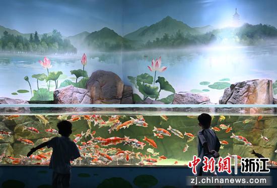 图为：小朋友在水族公园内观看锦鲤。王刚 摄