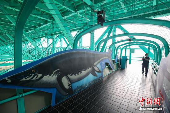 8月3日，花江峡谷大桥桥体观光区的古生物展区吸引游客。中新社记者 瞿宏伦 摄