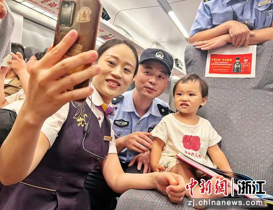 图为：乘警乘务员和旅客互动。中新社发 贺瑞明 摄