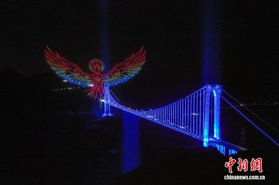 8月2日晚，花江峡谷大桥无人机光影秀。近日，位于贵州省关岭县与贞丰县交界处的世界第一高桥——花江峡谷大桥，开启无人机光影秀常态化表演。无人机在大桥上空编队飞行，变幻出多个图案，为前来观光的游客呈现了一场震撼的视觉盛宴。（无人机照片）